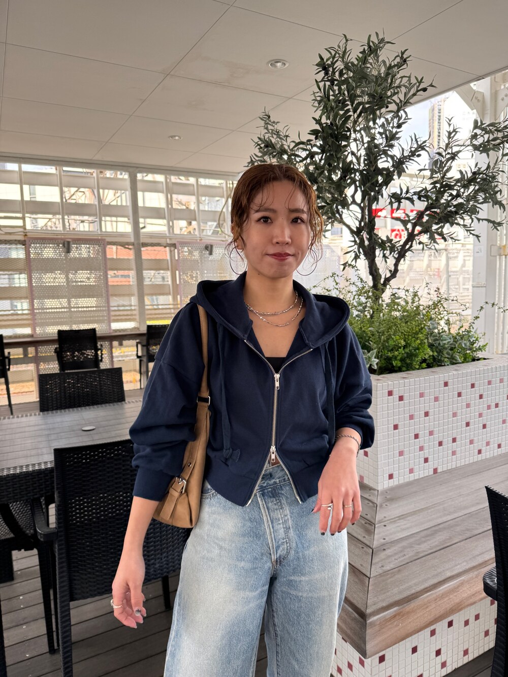 ブルー系のパーカー、ブルー系のデニムパンツ、シルバー系のネックレスを着用したレディースの冬コーディネートの6枚目の写真