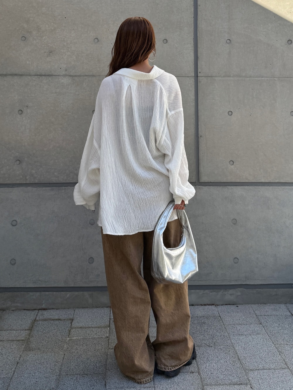 ブラウン系のデニムパンツ、ホワイト系のシャツ/ブラウスを着用したレディースの春コーディネートの3枚目の写真