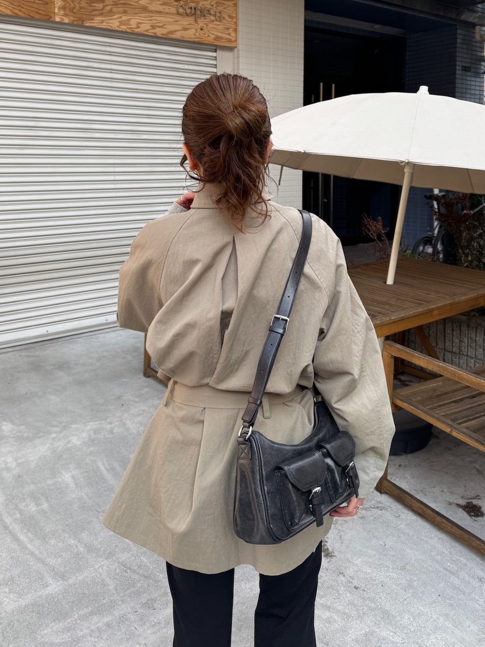 グリーン系のトレンチコート、ブラック系のその他パンツを着用したレディースの冬コーディネートの8枚目の写真