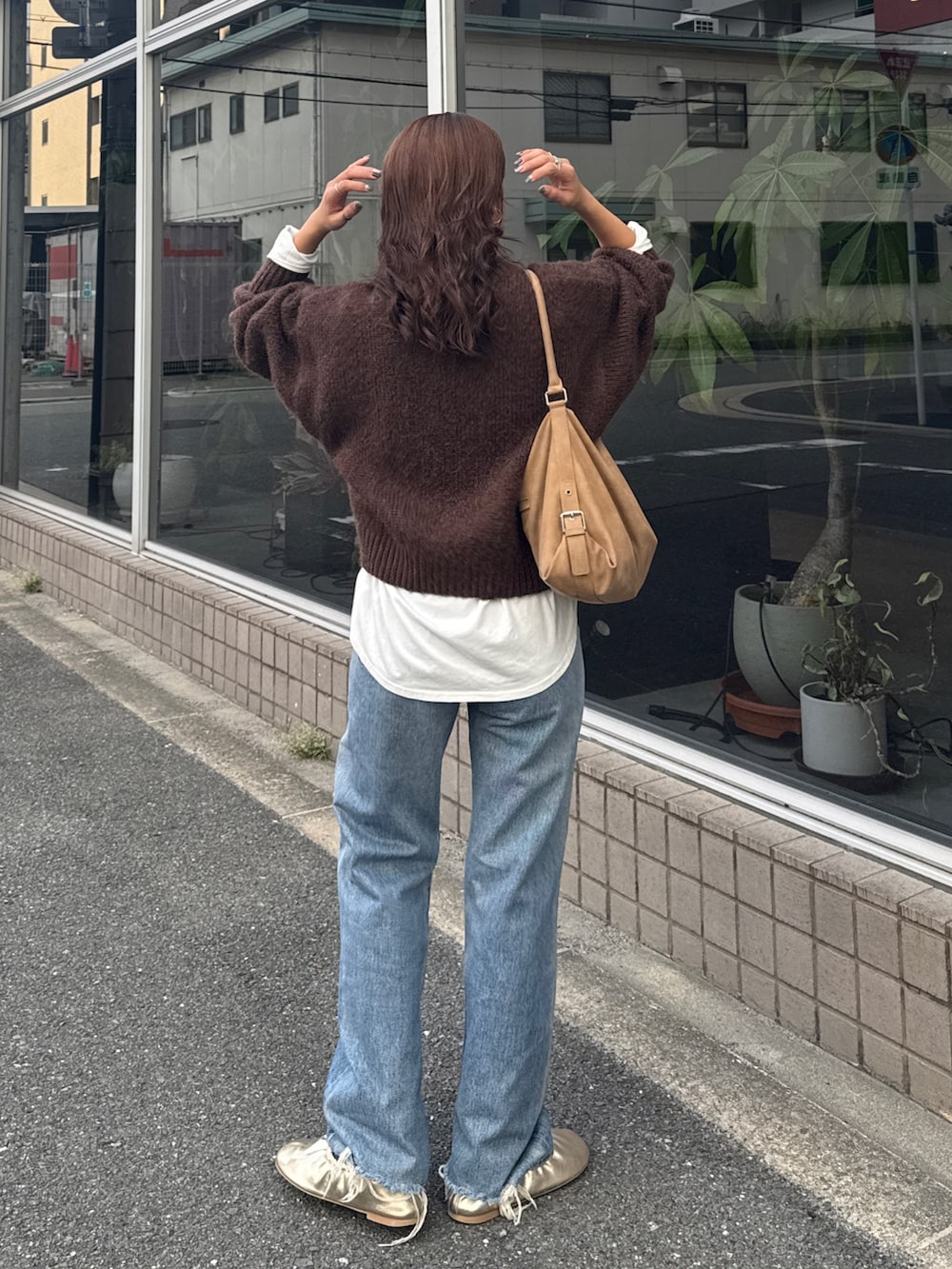 ホワイト系のTシャツ/カットソー、ブラウン系のニット/セーター、ブルー系のデニムパンツを着用したレディースの秋コーディネートの5枚目の写真