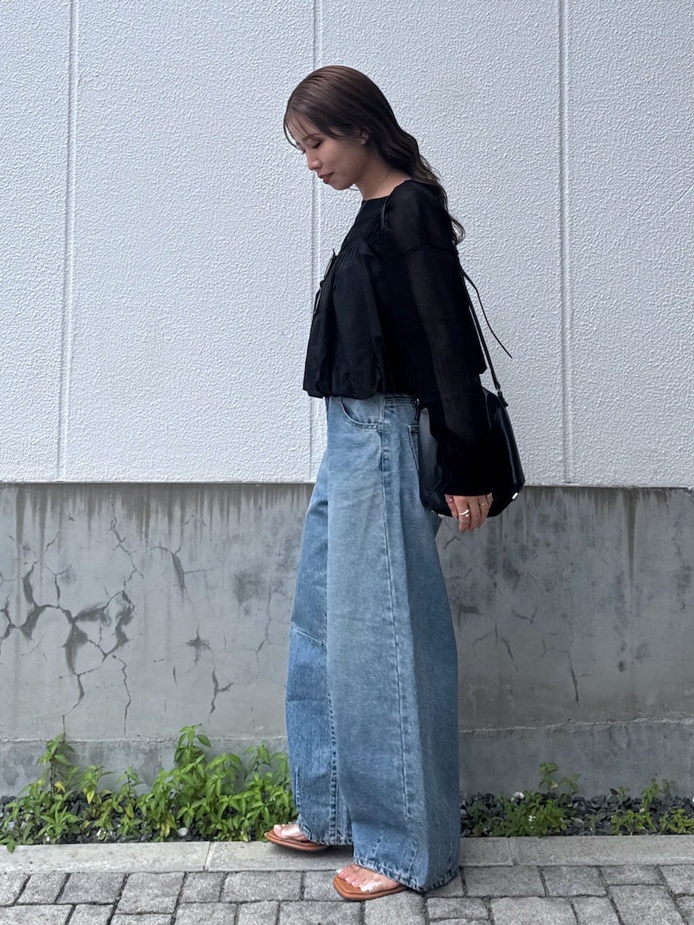 ブルー系のデニムパンツ、ブラック系のキャミソール、ブラック系のニット/セーターを着用したレディースの夏コーディネートの3枚目の写真
