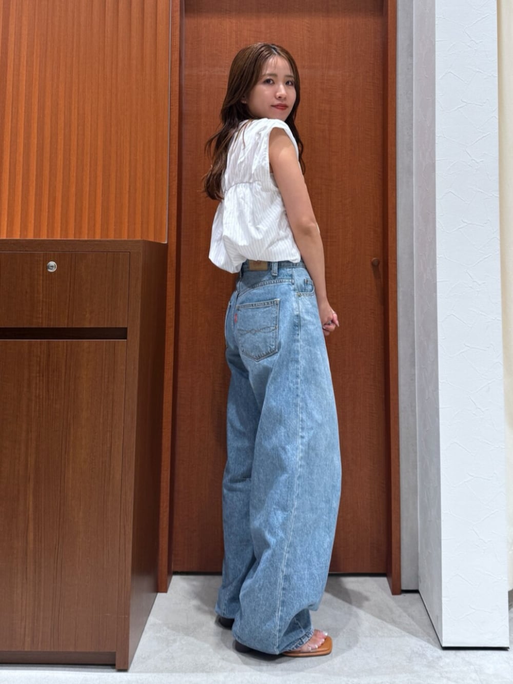 その他のサンダル、ホワイト系のシャツ/ブラウス、ブルー系のデニムパンツを着用したレディースの夏コーディネートの3枚目の写真