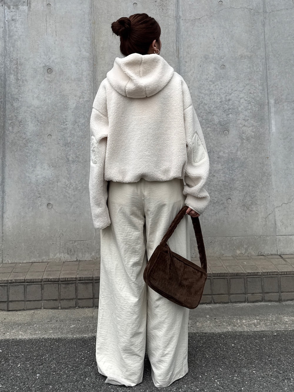 ホワイト系のパーカー、ホワイト系のその他パンツ、ブラウン系のハンドバッグを着用したレディースの秋コーディネートの5枚目の写真