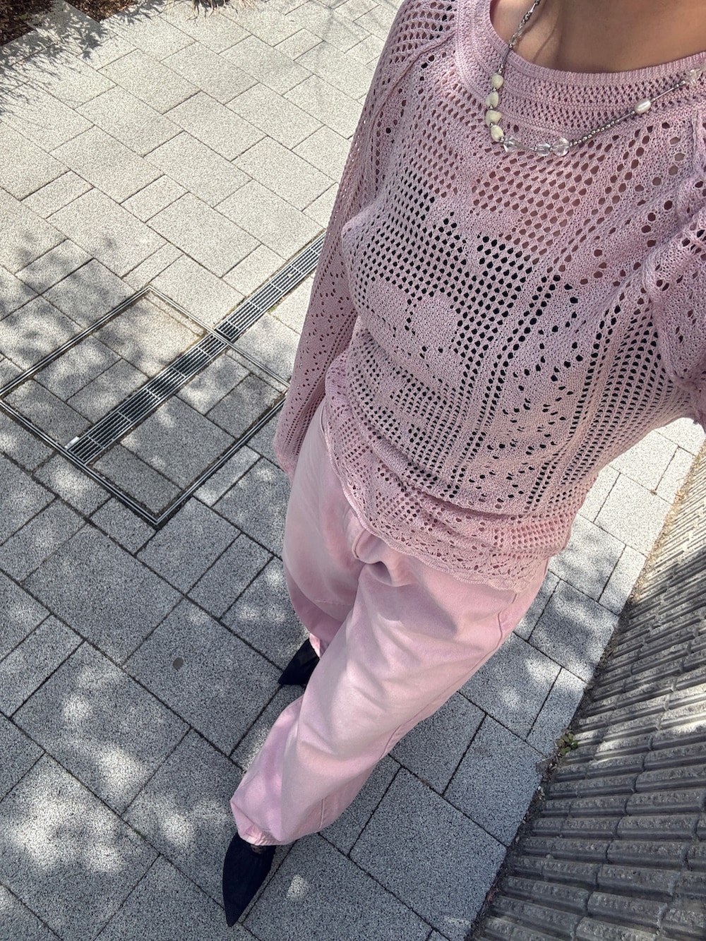 ピンク系のデニムパンツ、ピンク系のニット/セーター、ブラック系のパンプスを着用したレディースの春コーディネートの9枚目の写真