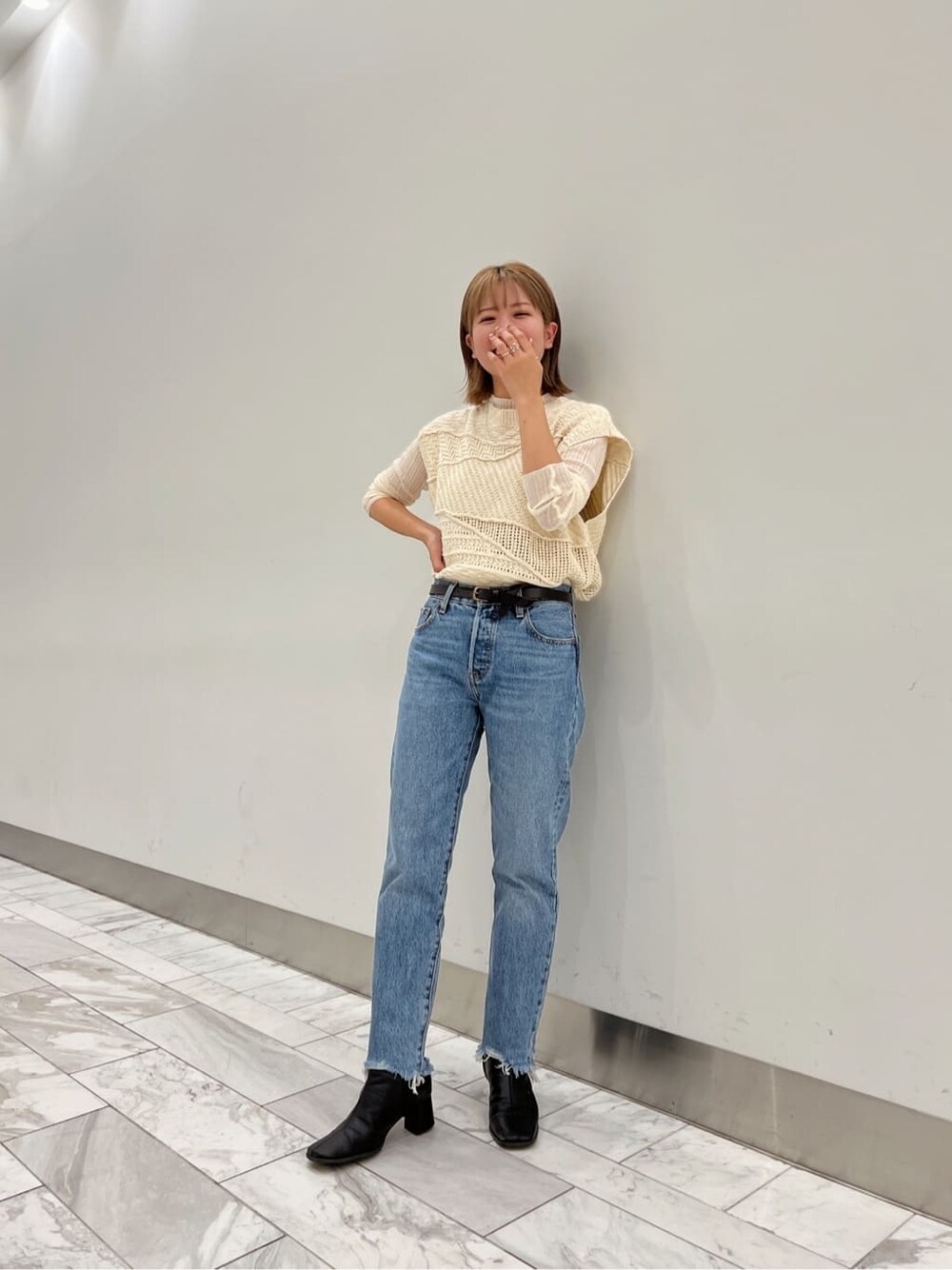 ブラック系のブーツ、ホワイト系のニット/セーター、ホワイト系のニット/セーターを着用したレディースの夏コーディネートの4枚目の写真