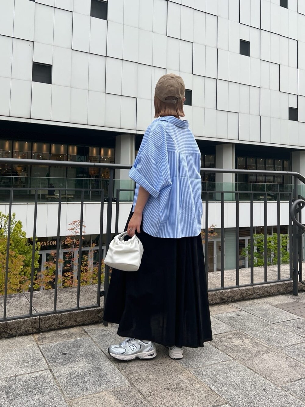 ブラック系のワンピース、ブルー系のシャツ/ブラウス、ホワイト系のハンドバッグを着用したレディースの春コーディネートの3枚目の写真