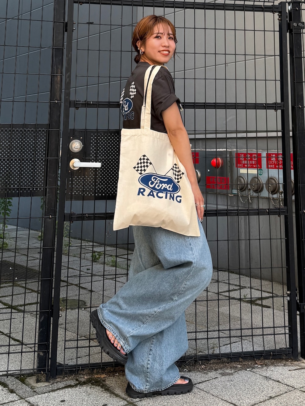 ブルー系のデニムパンツ、グレー系のTシャツ/カットソー、ホワイト系のトートバッグを着用したレディースの夏コーディネートの6枚目の写真