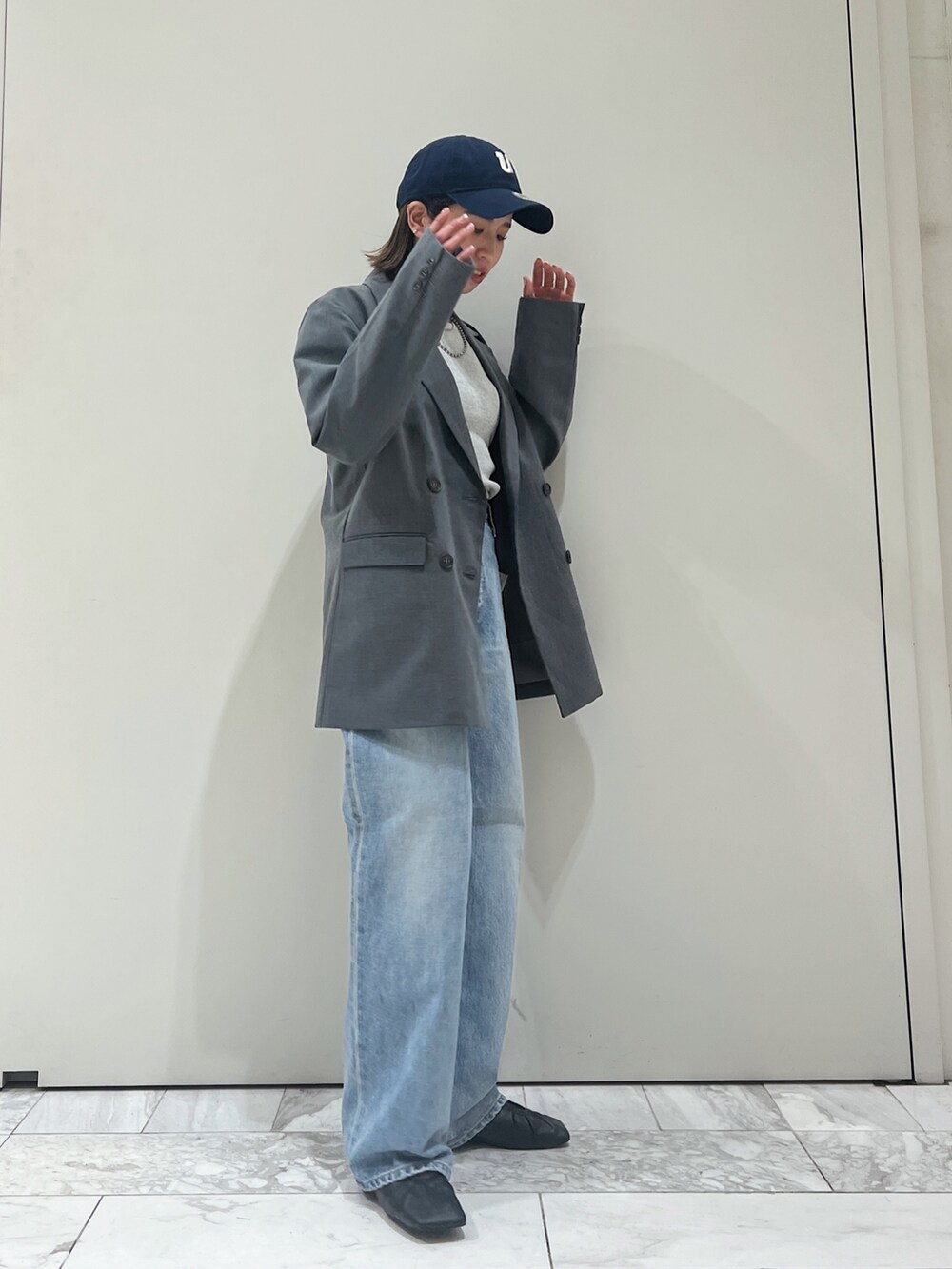 グレー系のテーラードジャケット、ブルー系のデニムパンツ、ブラック系のパンプスを着用したレディースの冬コーディネートの3枚目の写真