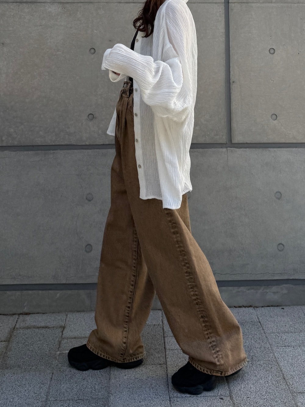 ブラウン系のデニムパンツ、ホワイト系のシャツ/ブラウスを着用したレディースの春コーディネートの4枚目の写真