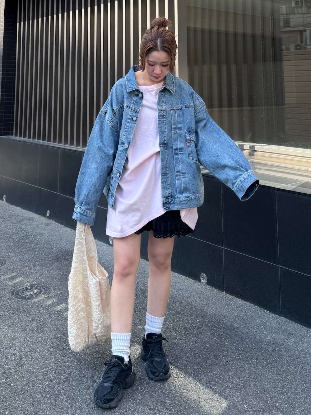 ピンク系のTシャツ/カットソー、ブルー系のデニムジャケット、ブラック系のその他パンツを着用したレディースの春コーディネートの2枚目の写真