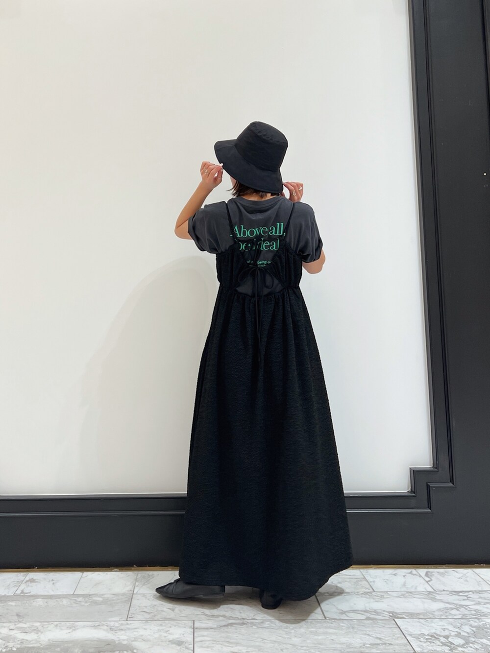 ブラック系のワンピース、グレー系のTシャツ/カットソー、ブラック系のパンプスを着用したレディースの春コーディネートの5枚目の写真