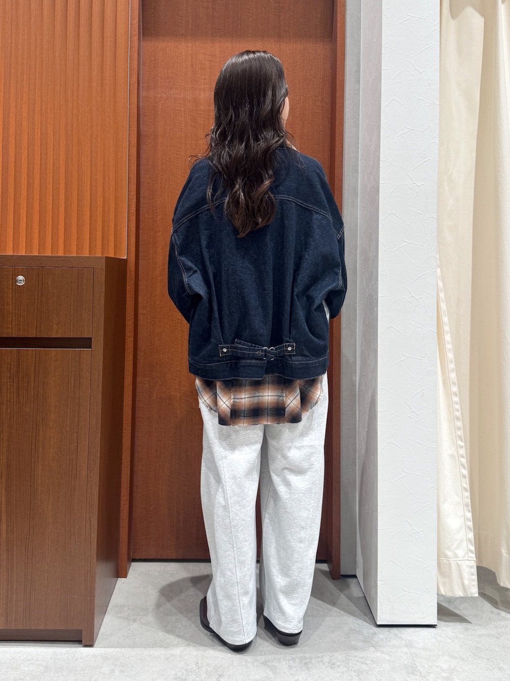 ブラウン系のシャツ/ブラウス、ブルー系のデニムジャケット、グレー系のスウェットパンツを着用したレディースの秋コーディネートの3枚目の写真