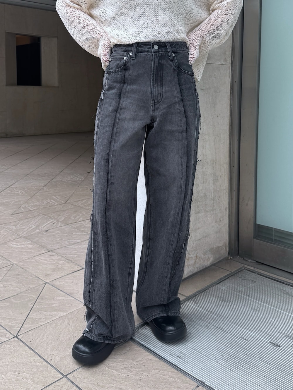 ブラック系のデニムパンツ、ホワイト系のタンクトップ、ホワイト系のニット/セーターを着用したレディースの夏コーディネートの5枚目の写真