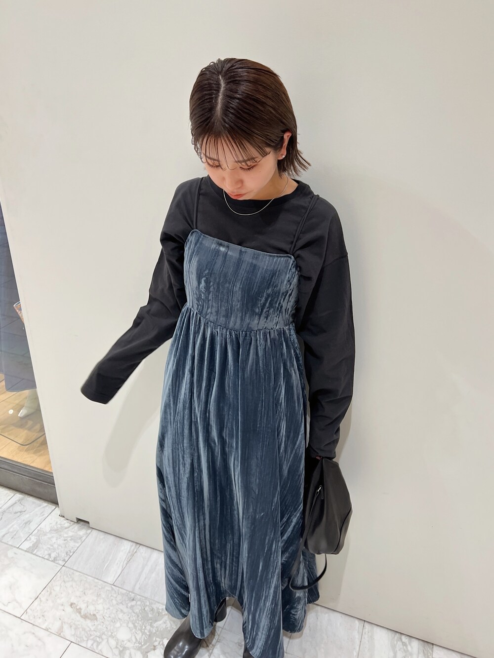 ブルー系のワンピース、ブラック系のTシャツ/カットソー、ブラック系のブーツを着用したレディースの冬コーディネートの8枚目の写真