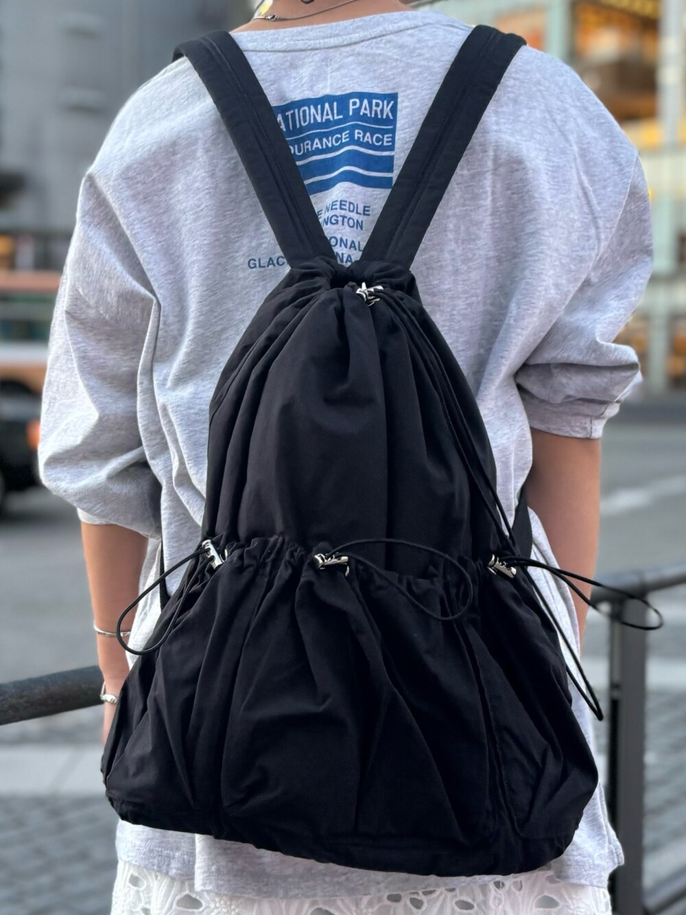 ブラック系のバックパック/リュック、ホワイト系のスカート、グレー系のTシャツ/カットソーを着用したレディースの冬コーディネートの8枚目の写真