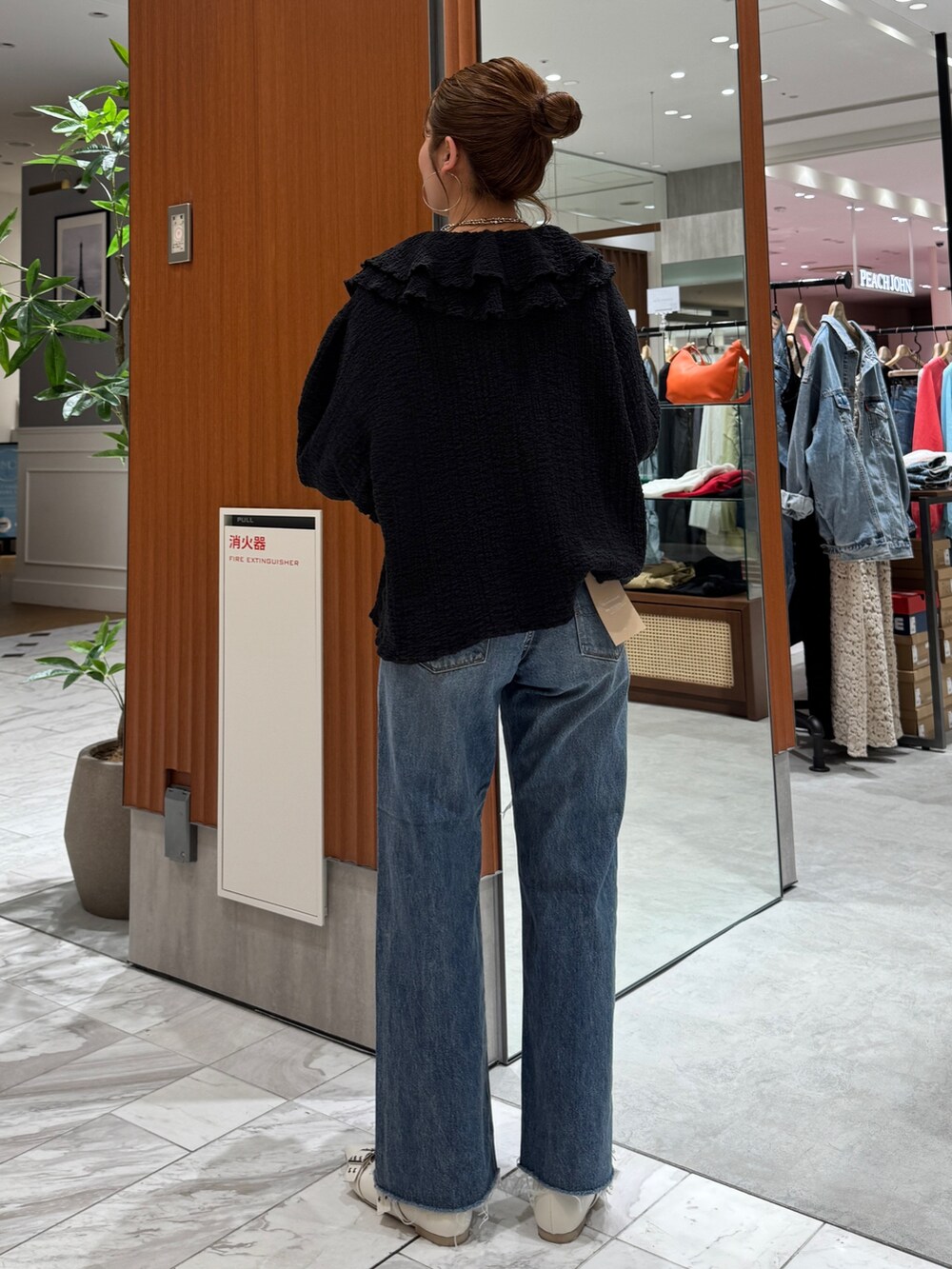 ブルー系のデニムパンツ、ブラック系のシャツ/ブラウス、ホワイト系のパンプスを着用したレディースの春コーディネートの4枚目の写真