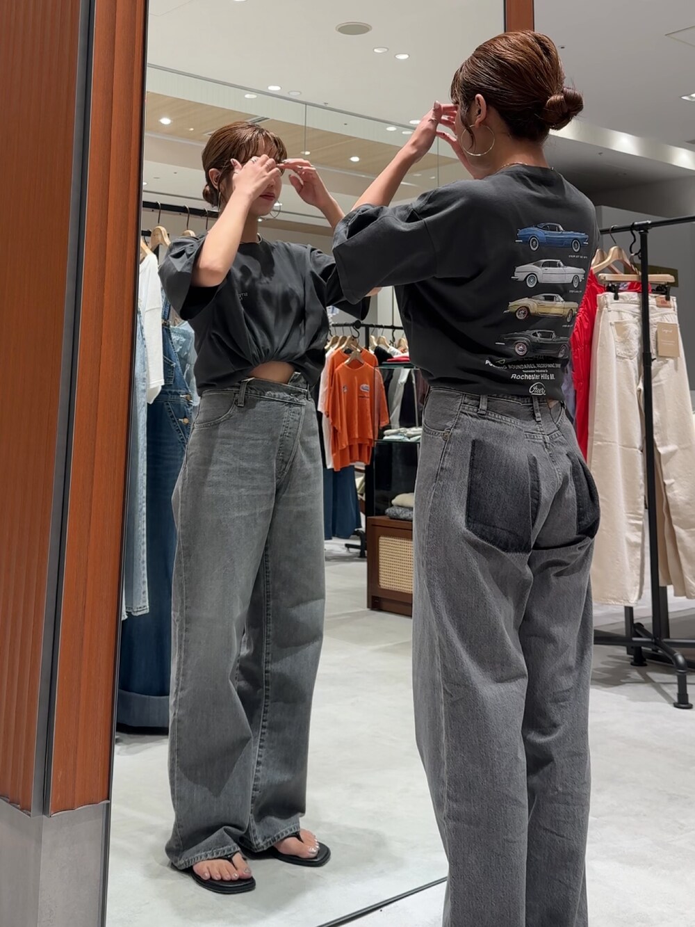 ブラック系のデニムパンツ、グレー系のTシャツ/カットソー、ブラック系のサンダルを着用したレディースの夏コーディネートの5枚目の写真