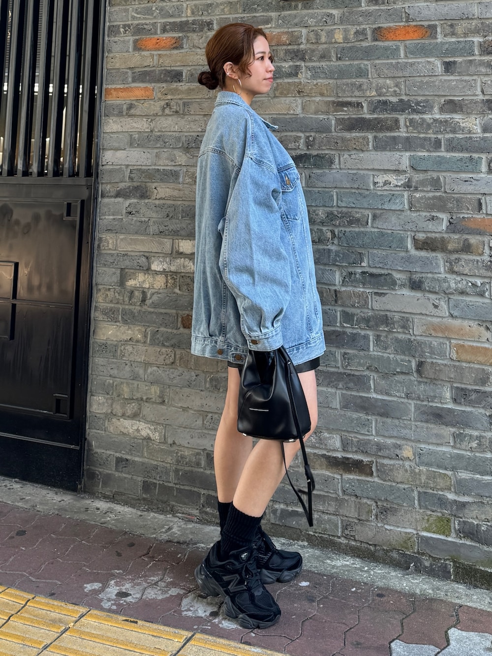 ブルー系のデニムジャケット、ブルー系のTシャツ/カットソー、ブラック系のその他パンツを着用したレディースの冬コーディネートの4枚目の写真