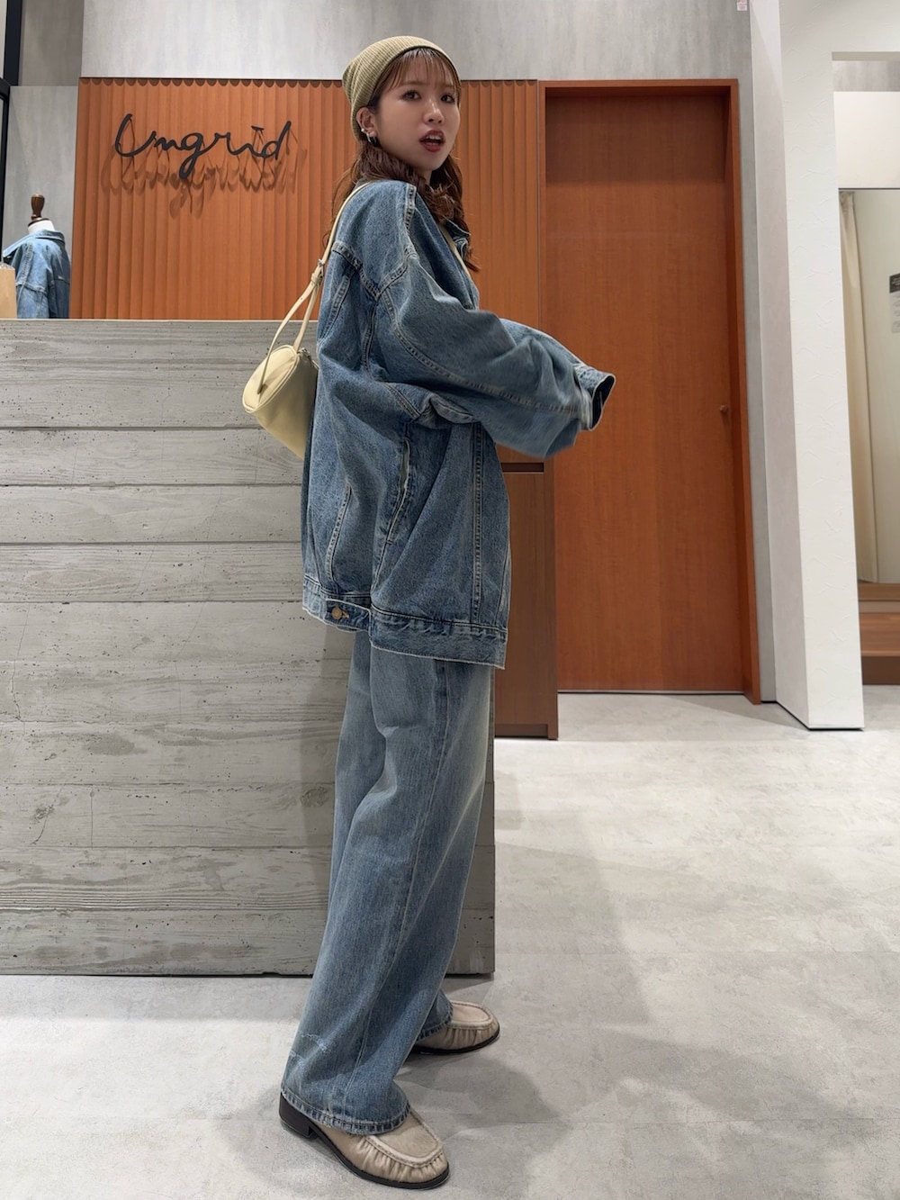 ブルー系のデニムジャケット、ブルー系のデニムパンツ、ホワイト系のタンクトップを着用したレディースの夏コーディネートの2枚目の写真