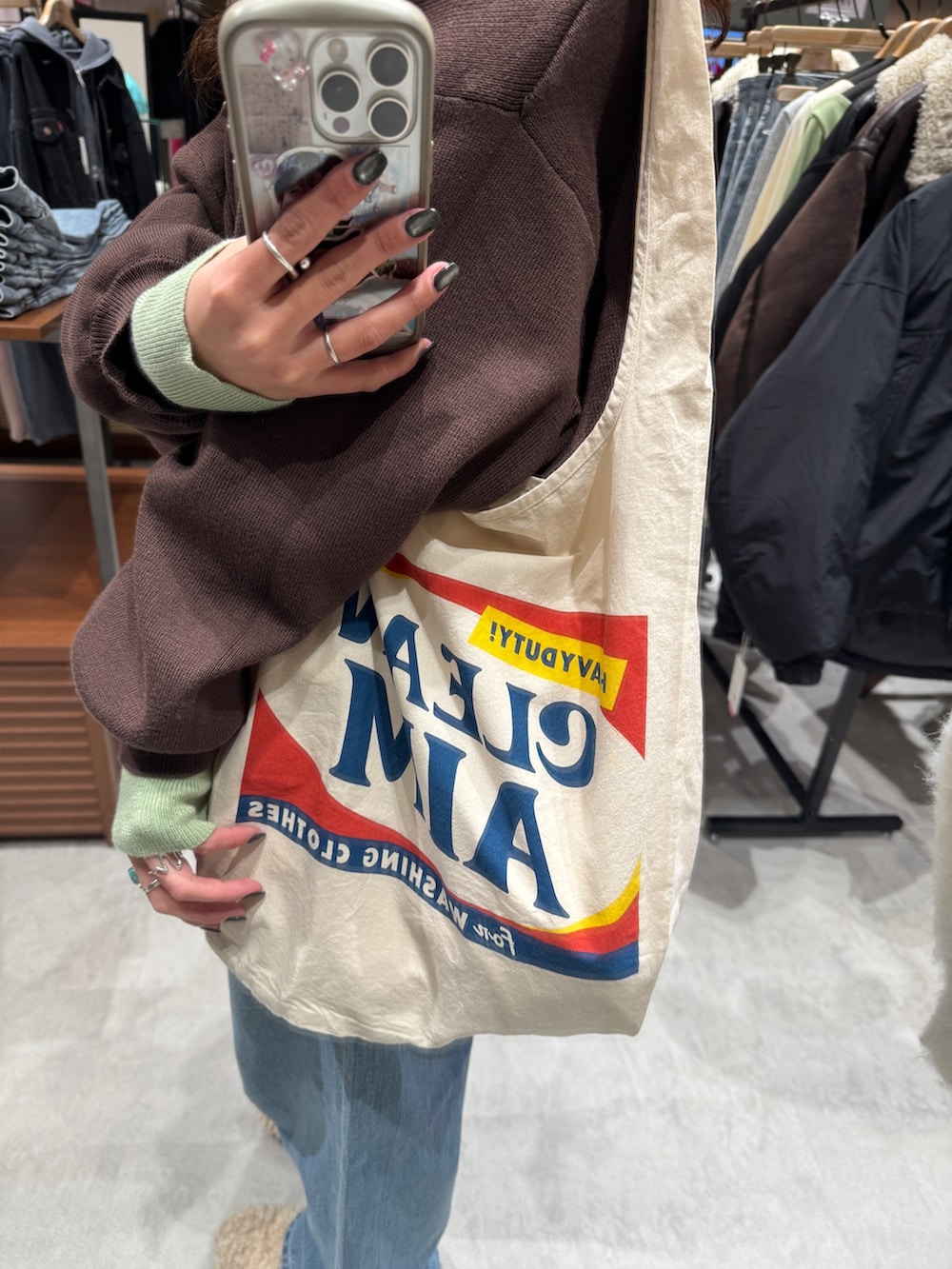 ブルー系のデニムパンツ、ブラウン系のニット/セーター、ホワイト系のトートバッグを着用したレディースの冬コーディネートの9枚目の写真