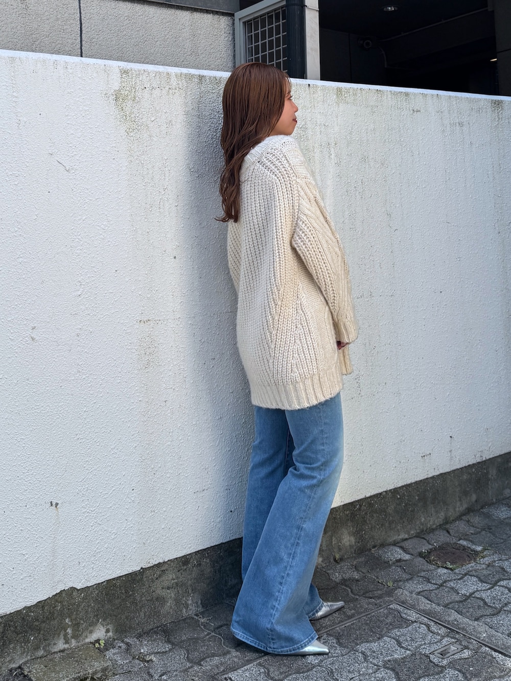 ホワイト系のニット/セーター、ブルー系のデニムパンツ、シルバー系のその他シューズを着用したレディースの夏コーディネートの5枚目の写真