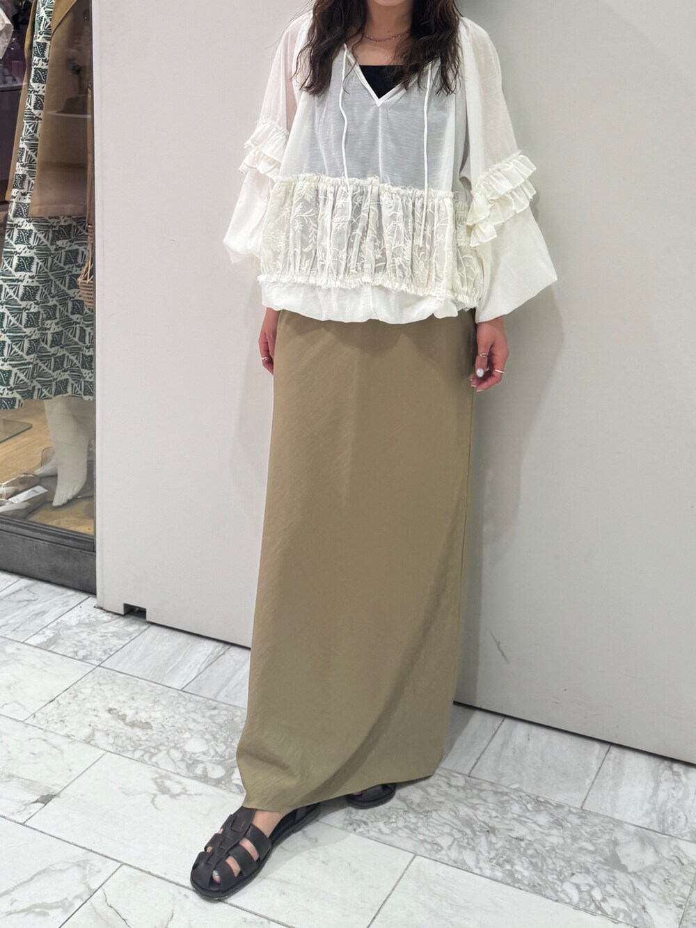 ベージュ系のスカート、ホワイト系のシャツ/ブラウス、ブラック系のキャミソールを着用したレディースの春コーディネートの5枚目の写真