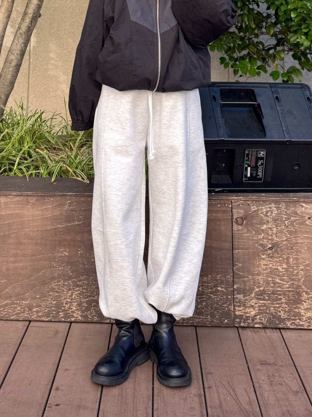 グレー系のスウェットパンツ、ブラック系のブルゾンを着用したレディースの秋コーディネートの2枚目の写真