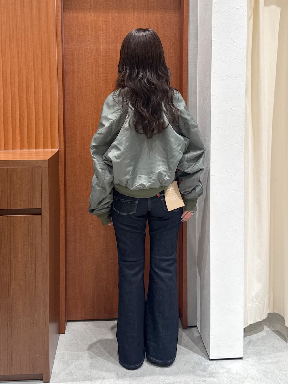 ブルー系のデニムパンツ、グレー系のTシャツ/カットソー、グリーン系のMA-1を着用したレディースの秋コーディネートの4枚目の写真