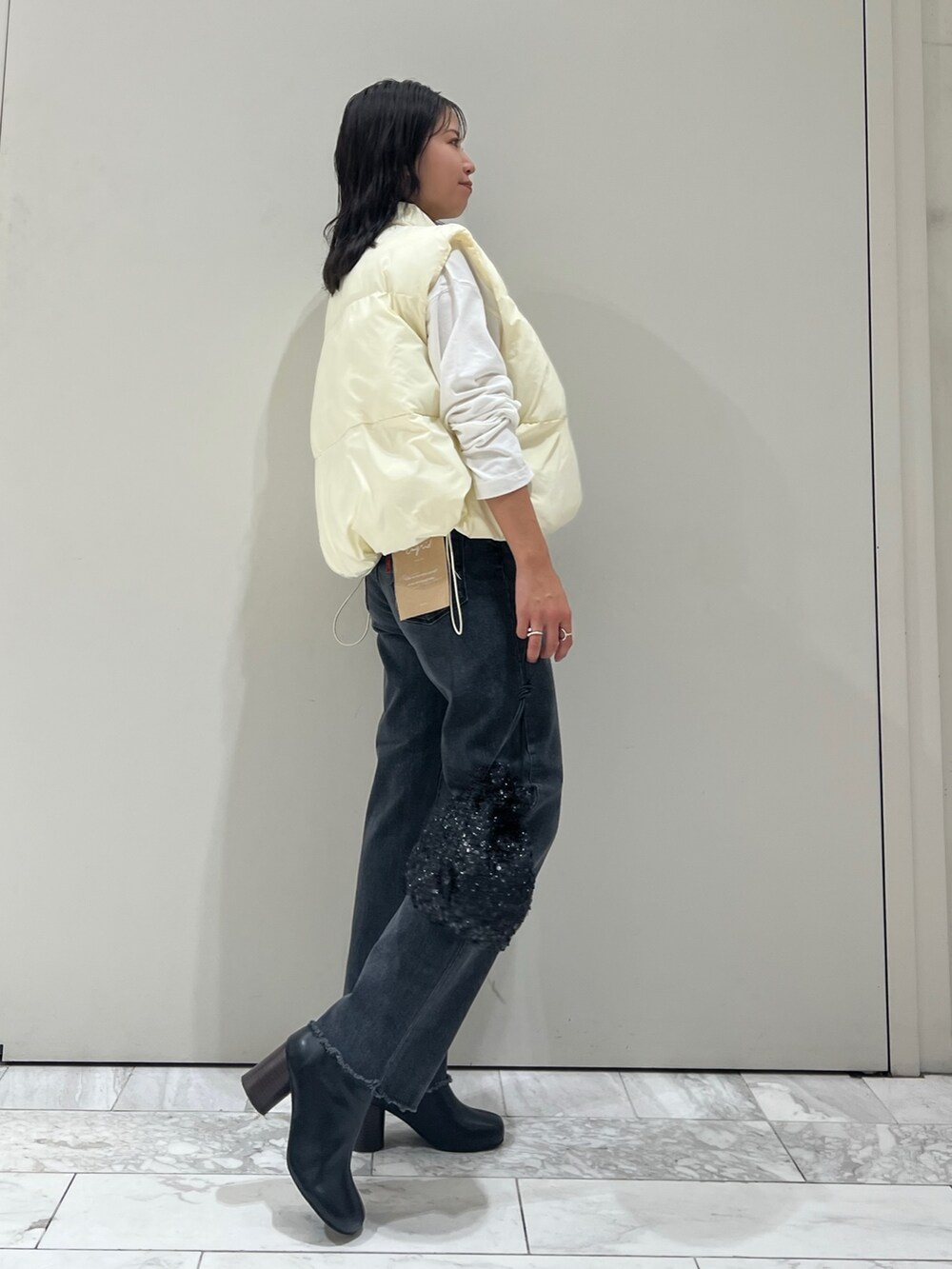 ブラック系のブーツ、ホワイト系のTシャツ/カットソー、ブラック系のデニムパンツを着用したレディースの秋コーディネートの7枚目の写真