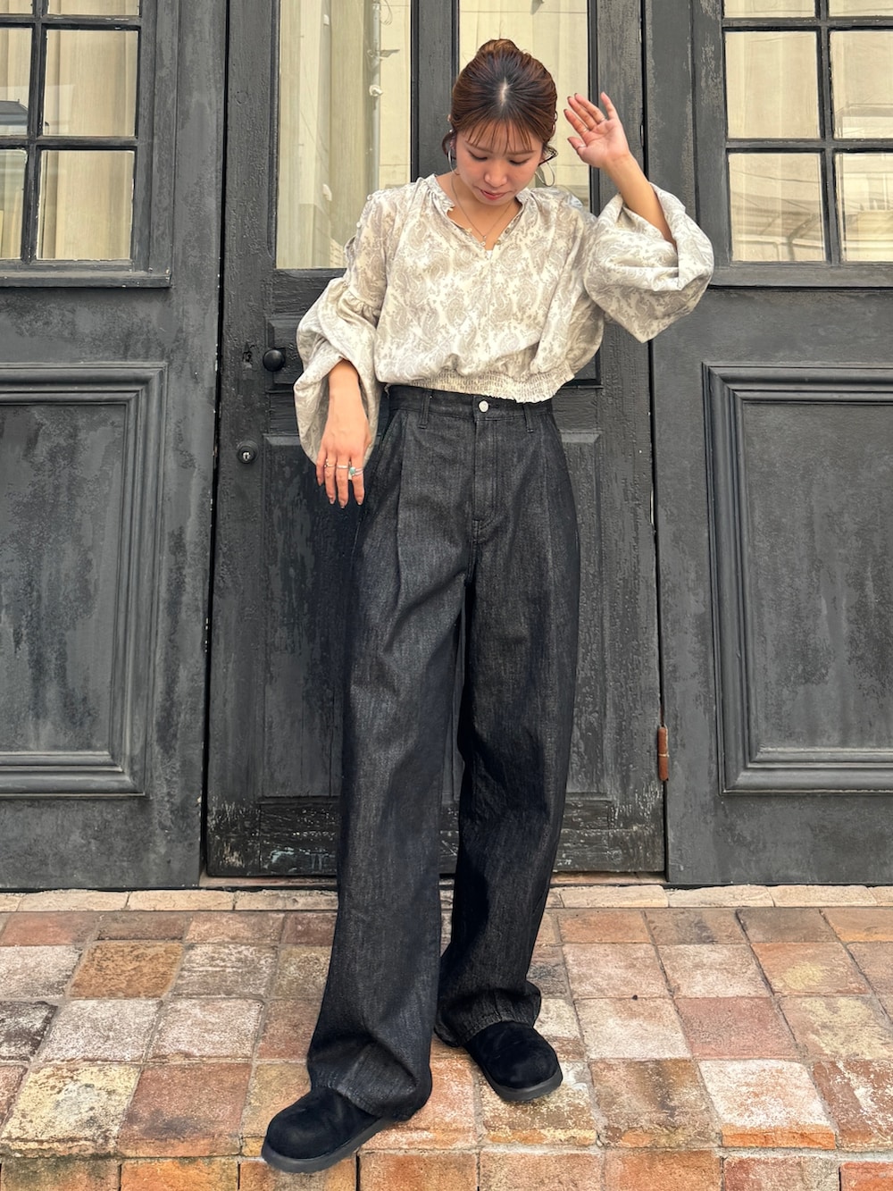 ブラック系のデニムパンツ、ブラック系のスリッポン、ホワイト系のシャツ/ブラウスを着用したレディースの秋コーディネートの2枚目の写真