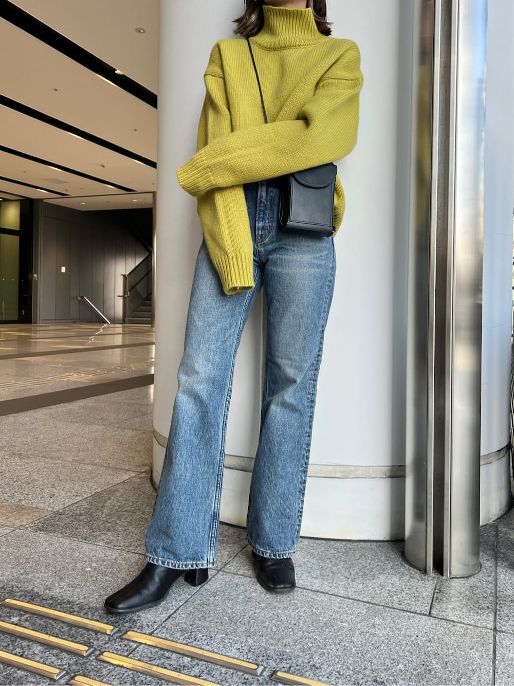 ブルー系のデニムパンツ、グリーン系のニット/セーターを着用したレディースの冬コーディネートの3枚目の写真