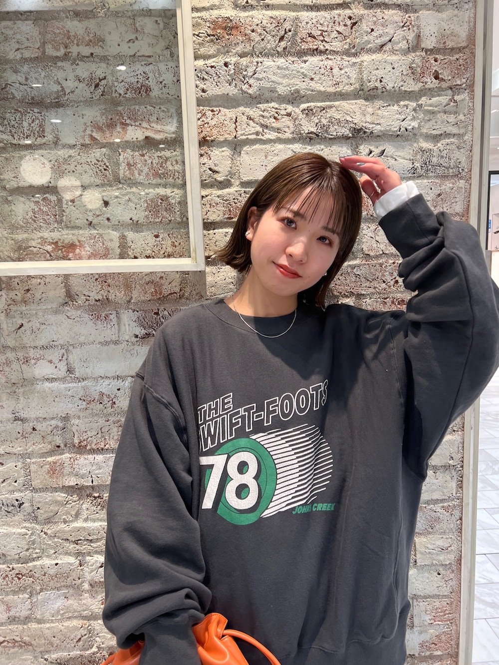 グレー系のスウェット、ブラック系のワンピース、ブルー系のデニムパンツを着用したレディースの冬コーディネートの6枚目の写真