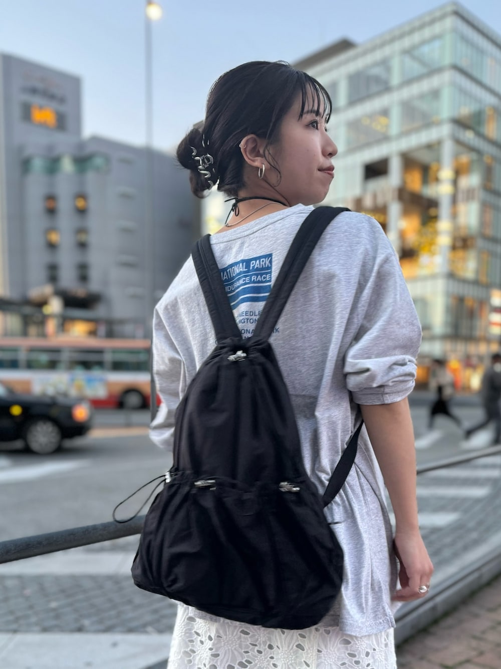 ブラック系のバックパック/リュック、ホワイト系のスカート、グレー系のTシャツ/カットソーを着用したレディースの冬コーディネートの7枚目の写真