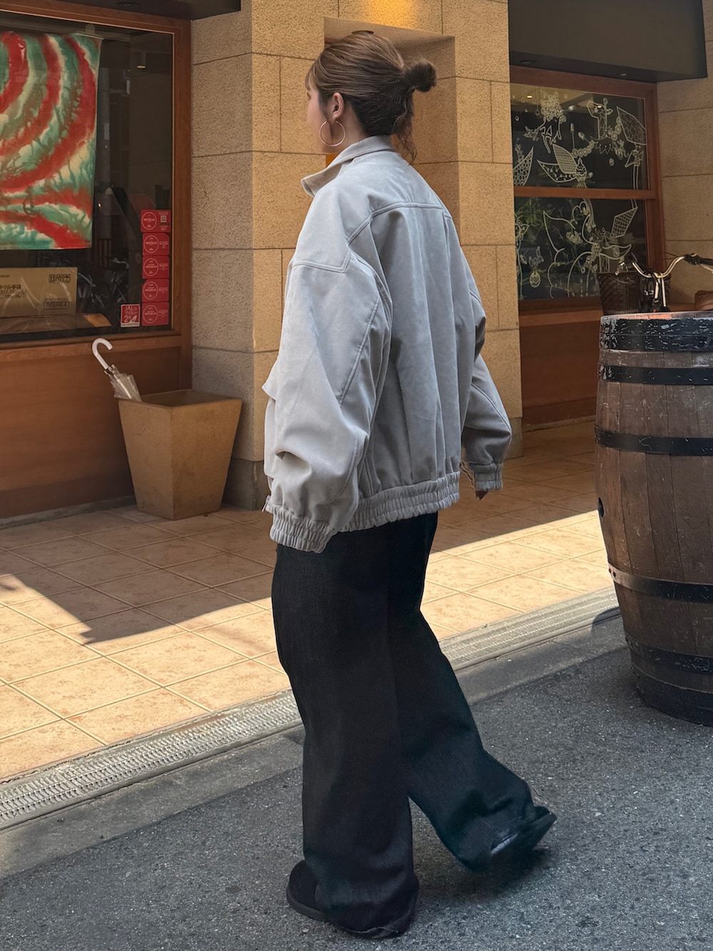 ベージュ系のブルゾン、ブラック系のデニムパンツ、ブラック系のスリッポンを着用したレディースの秋コーディネートの4枚目の写真