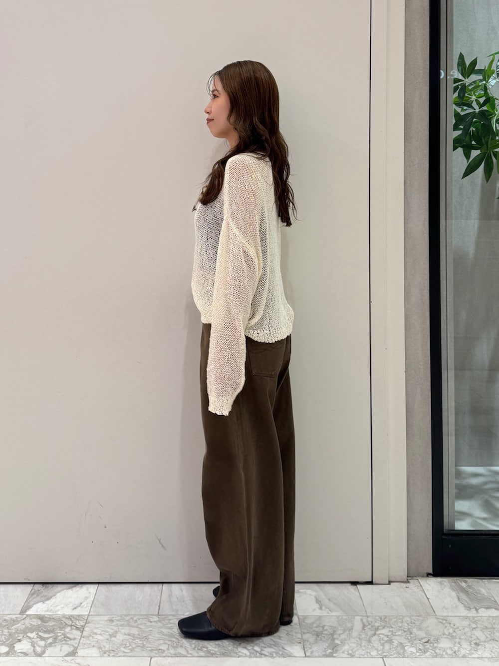 ブラウン系のデニムパンツ、ホワイト系のニット/セーター、ブラック系のサンダルを着用したレディースの秋コーディネートの7枚目の写真