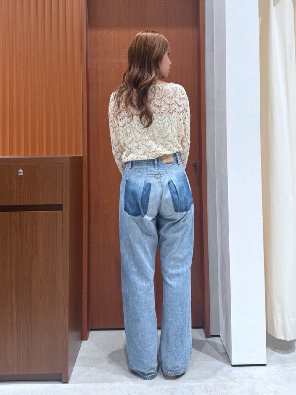 ブルー系のデニムパンツ、ホワイト系のニット/セーターを着用したレディースの夏コーディネートの3枚目の写真