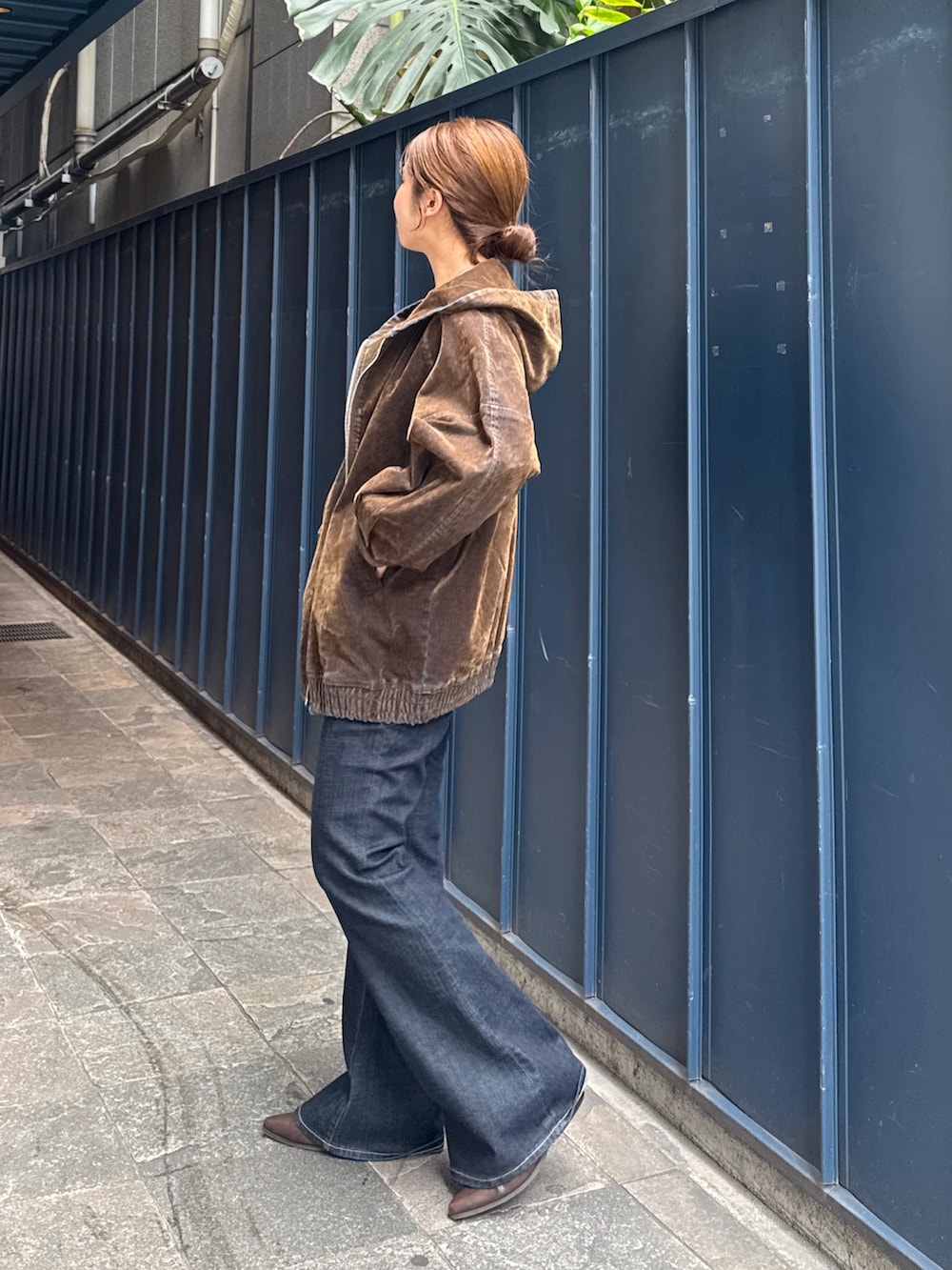 ブラック系のニット/セーター、ブラウン系のブルゾン、ブルー系のデニムパンツを着用したレディースの秋コーディネートの5枚目の写真