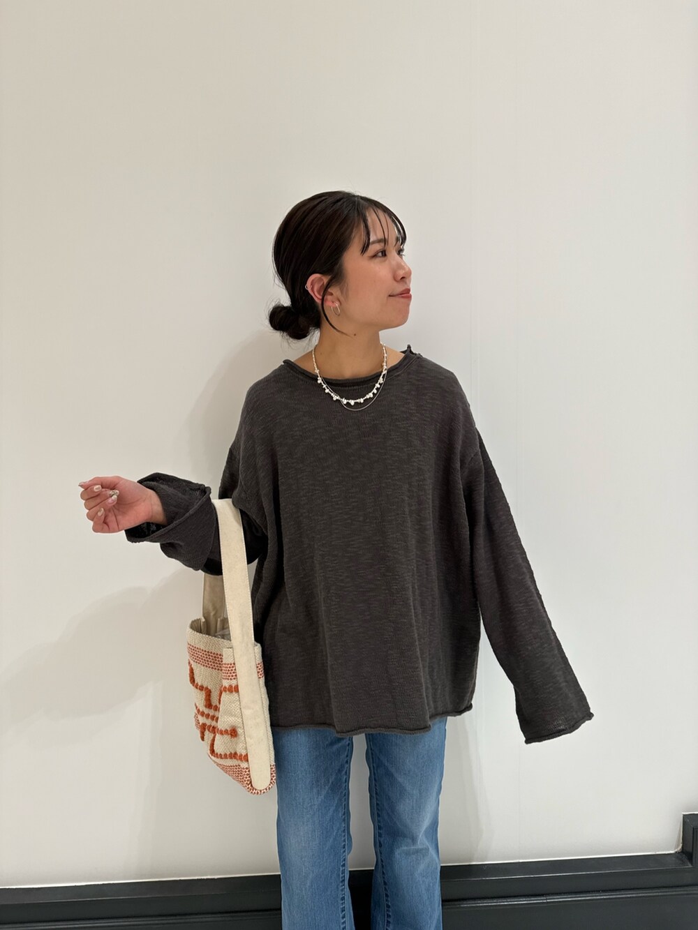 グレー系のニット/セーター、ブルー系のデニムパンツ、ブラック系のサンダルを着用したレディースの春コーディネートの8枚目の写真