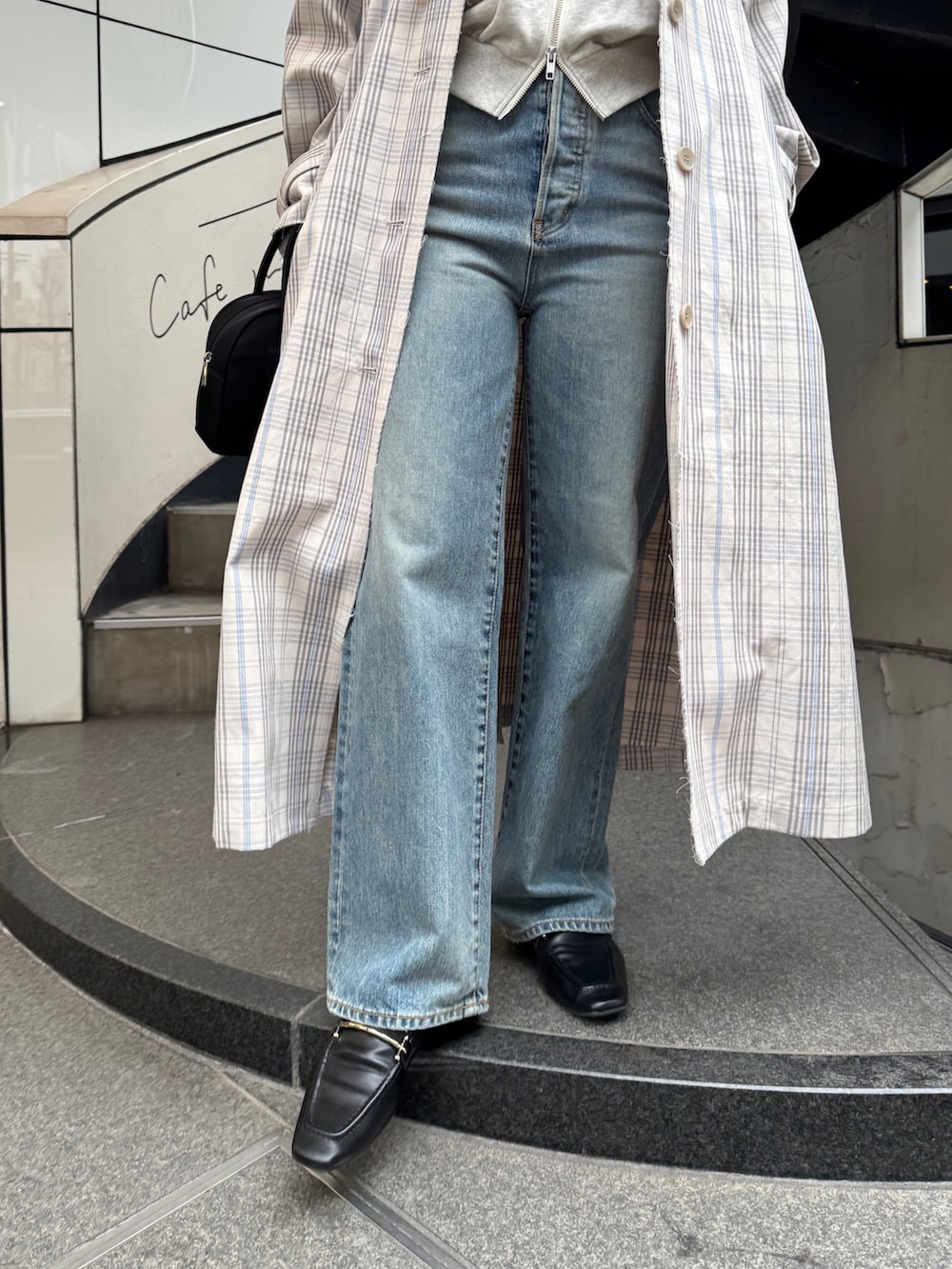 その他のステンカラーコート、ブラック系のボストンバッグ、ホワイト系のパーカーを着用したレディースの冬コーディネートの9枚目の写真