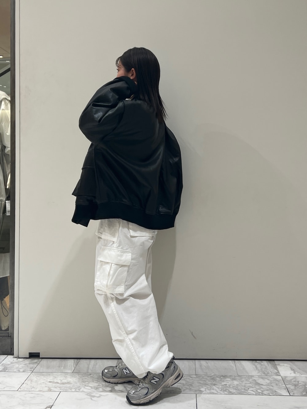 グレー系のニット/セーター、ホワイト系のカーゴパンツ、ブラック系のブルゾンを着用したレディースの秋コーディネートの6枚目の写真