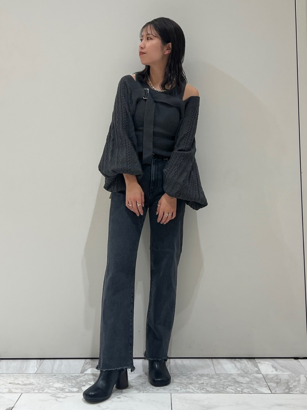 グレー系のカーディガン/ボレロ、ブラック系のデニムパンツ、ブラック系のブーツを着用したレディースの秋コーディネートの3枚目の写真