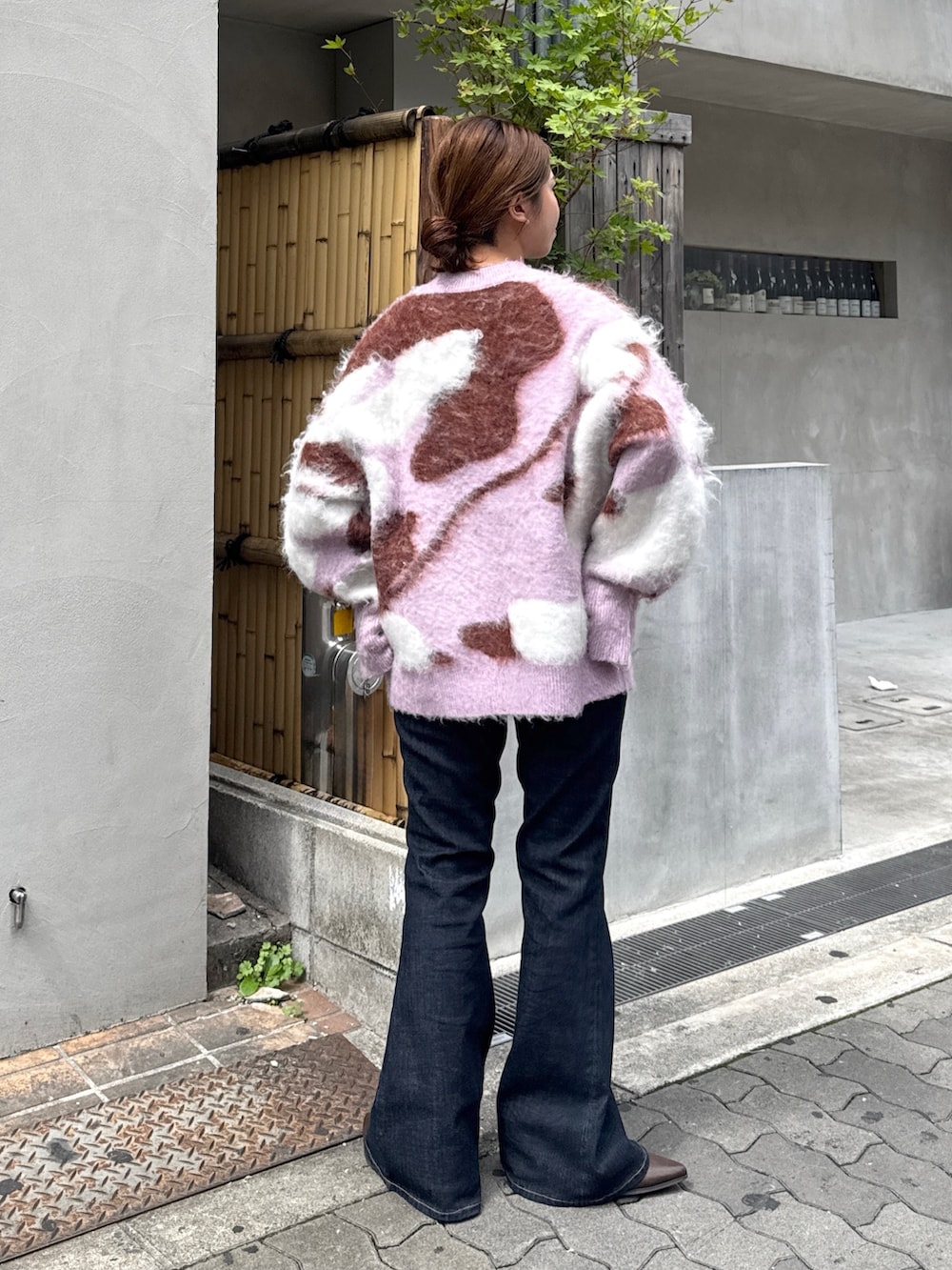 ブルー系のデニムパンツ、ブラウン系のブーツ、ピンク系のニット/セーターを着用したレディースの秋コーディネートの3枚目の写真