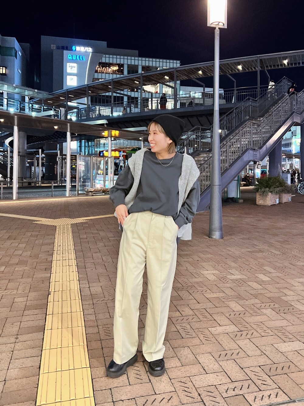 グレー系のTシャツ/カットソー、グレー系のニット/セーター、ベージュ系のスラックスを着用したレディースの冬コーディネートの3枚目の写真