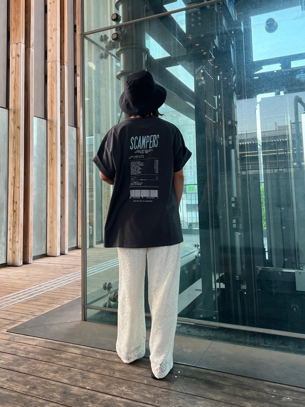 グレー系のTシャツ/カットソー、ホワイト系のその他パンツ、ブラック系のサンダルを着用したレディースの春コーディネートの4枚目の写真