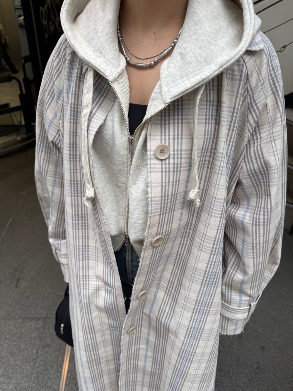 その他のステンカラーコート、ブラック系のボストンバッグ、ホワイト系のパーカーを着用したレディースの冬コーディネートの10枚目の写真