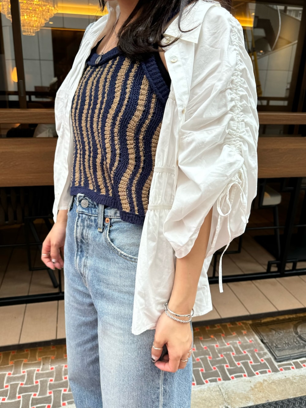 ブルー系のデニムパンツ、ホワイト系のシャツ/ブラウス、シルバー系のハンドバッグを着用したレディースの春コーディネートの9枚目の写真