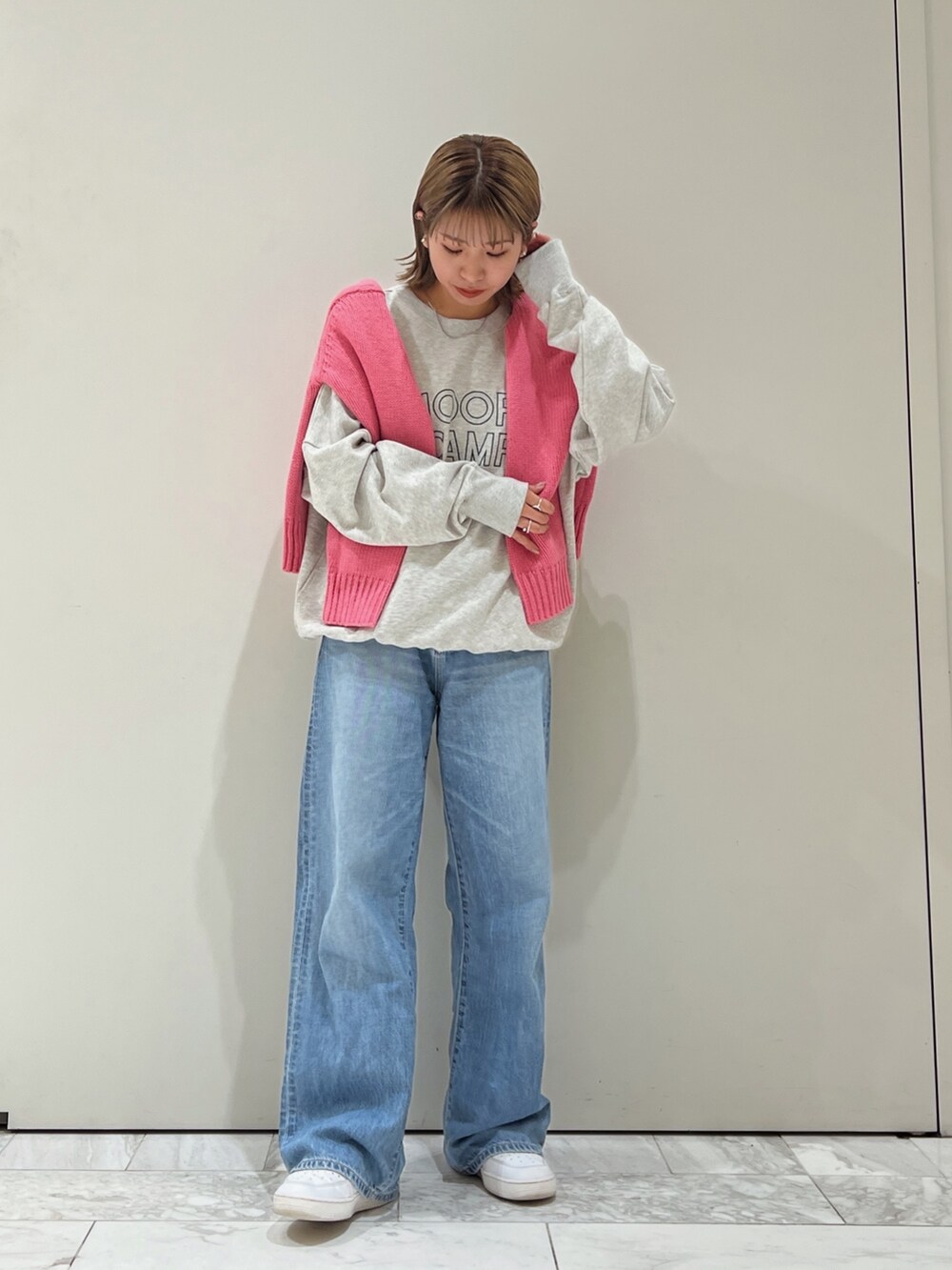 ピンク系のニット/セーター、グレー系のスウェット、ブルー系のデニムパンツを着用したレディースの秋コーディネートの5枚目の写真