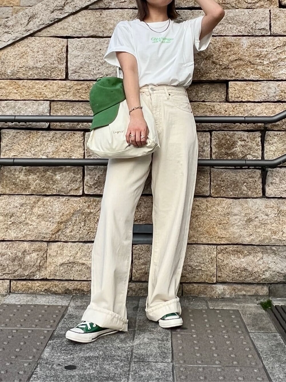 ホワイト系のデニムパンツ、ホワイト系のTシャツ/カットソー、グリーン系のキャップを着用したレディースの春コーディネートの2枚目の写真