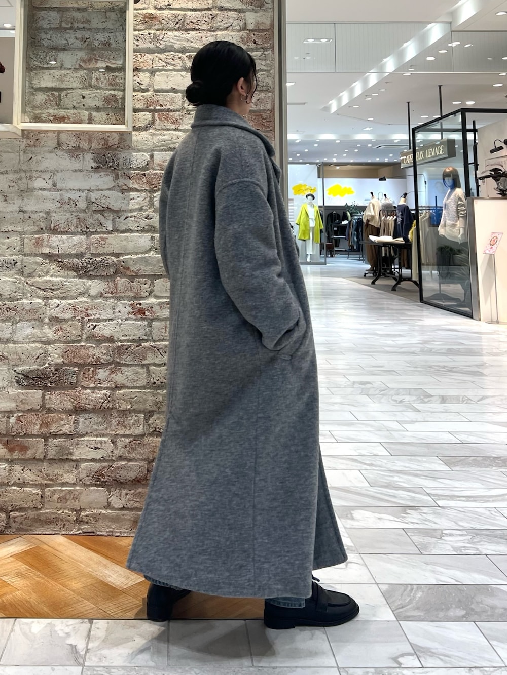 グレー系のニット/セーター、ブルー系のデニムパンツ、ブラック系のローファーを着用したレディースの秋コーディネートの2枚目の写真