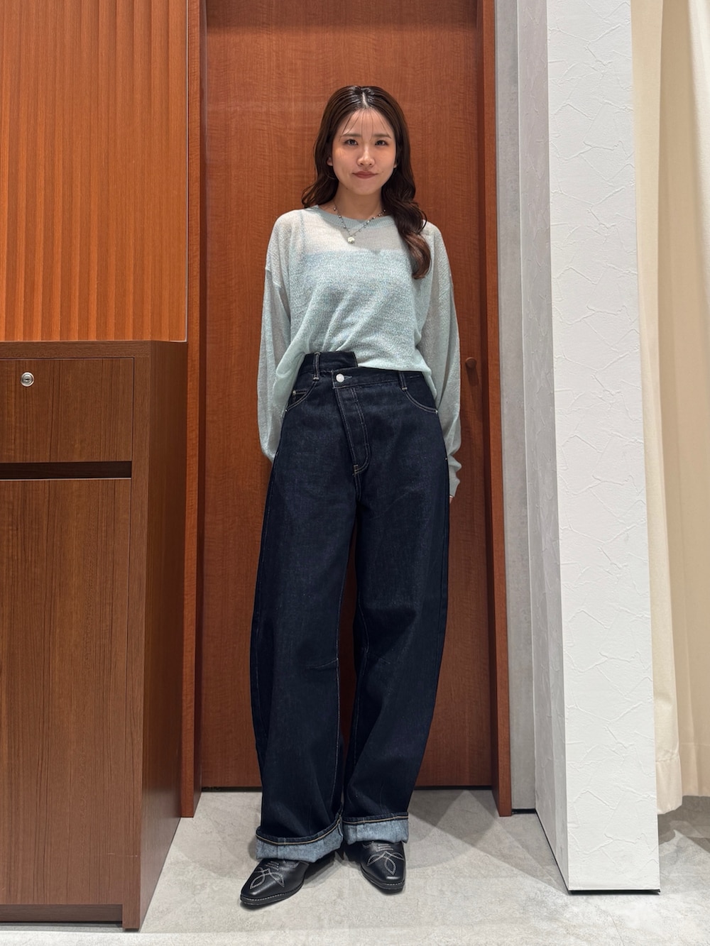 グリーン系のニット/セーター、ブルー系のデニムパンツ、ブラック系のその他シューズを着用したレディースの秋コーディネートの2枚目の写真